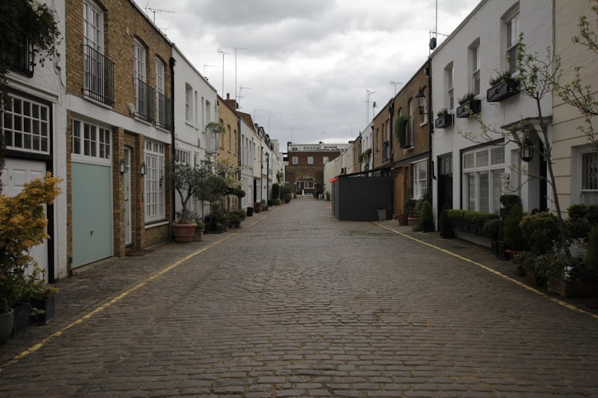 A cobbled London street lined with brick buildings